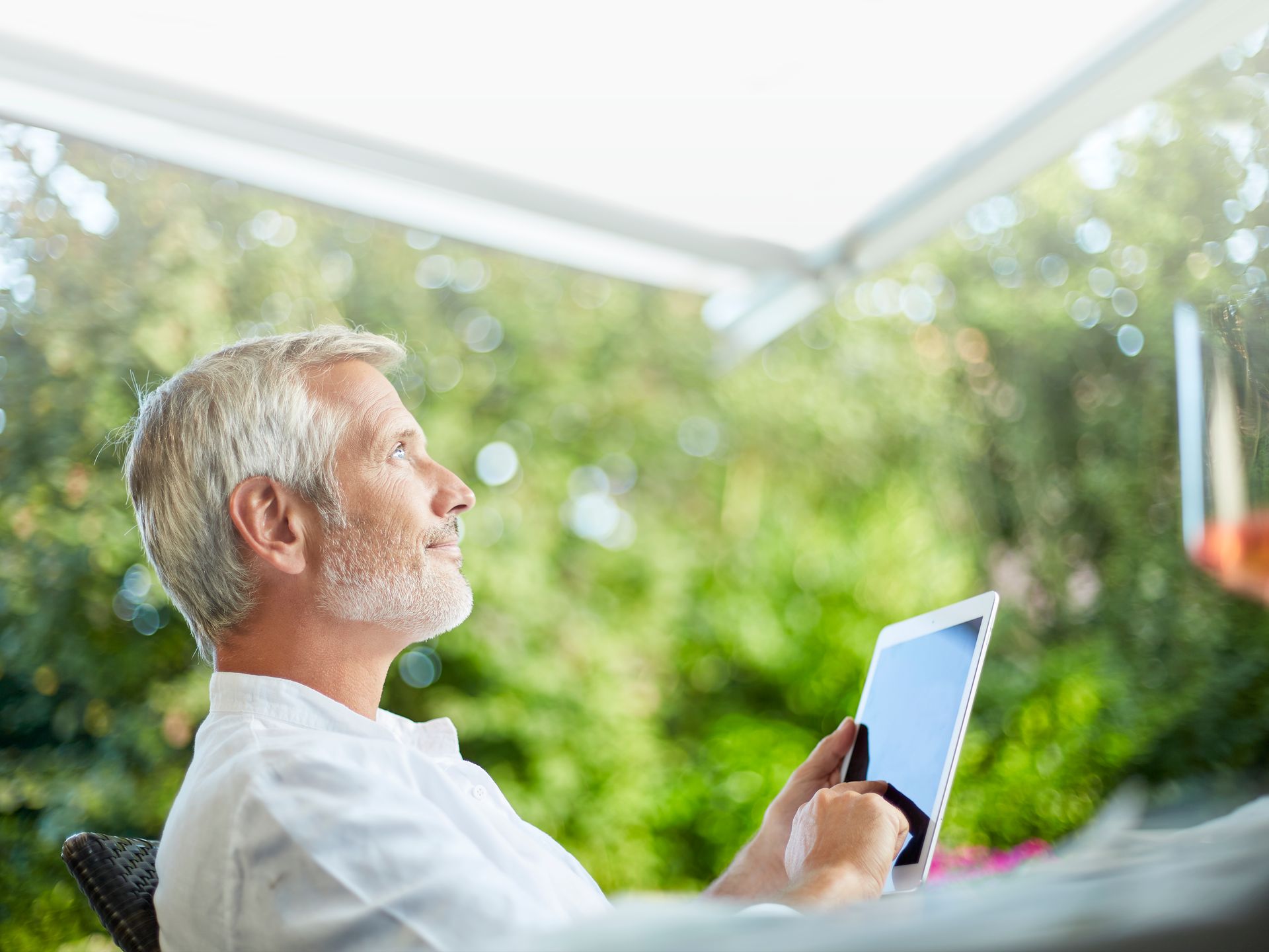 Man Sits Under Awning And Controls It With An iPad - Shade-Space