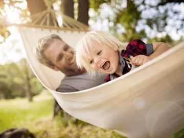 Lovely Modern Dad Enjoys The Outdoors Playing With His Son On A White Hammock - Shade-Space