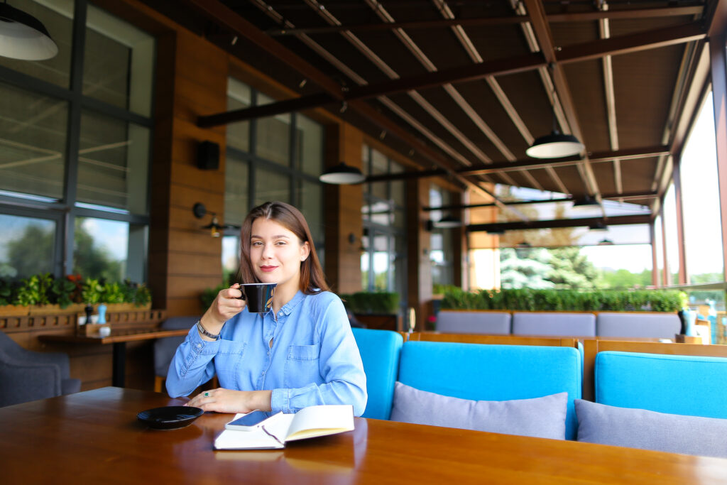 Young Woman Resting at Cafe with Smartphone, Pergola System - Shade-Space