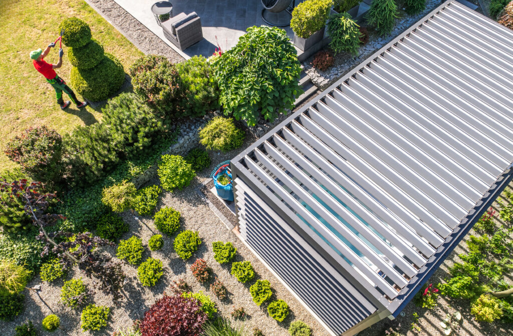 Motorised aluminium louvre roof pergola installed over a garden patio, creating a modern outdoor living and dining space - Shade Space